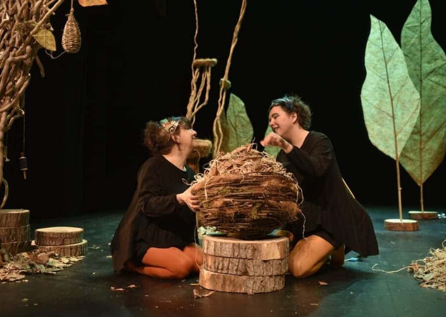 Les deux comédiennes sont à genoux autour d'un nid géant.