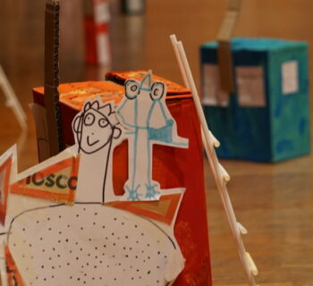 Figurines de papier et maison de carton créées au cours d'un atelier.